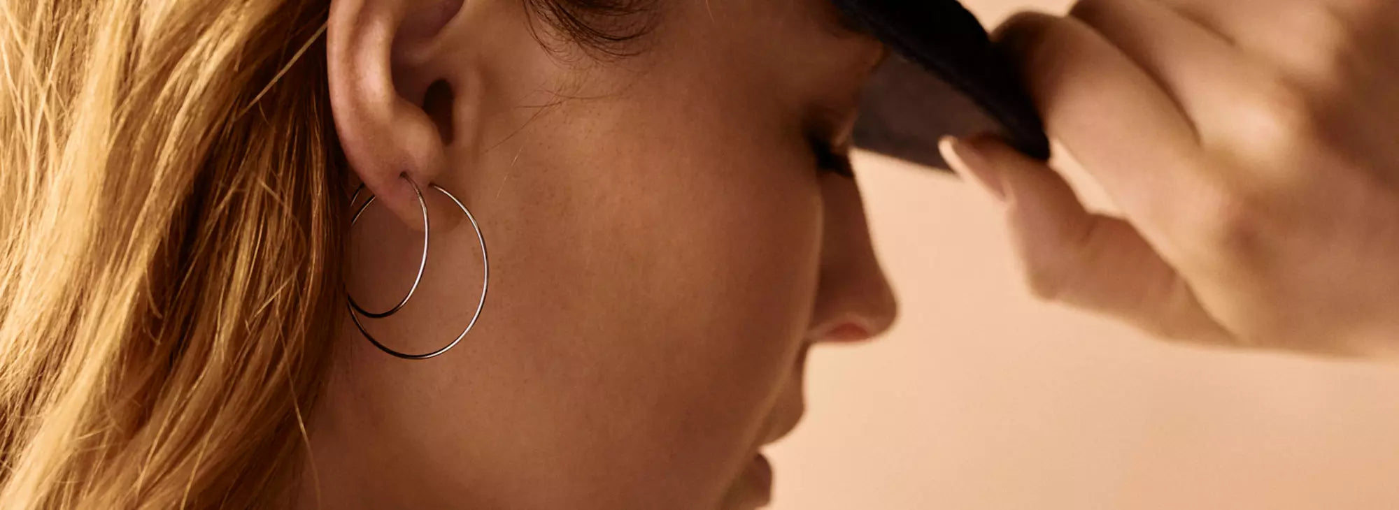 Op deze foto zie je een vrouw met de titanium oorringen in 2 verschillende afmetingen
