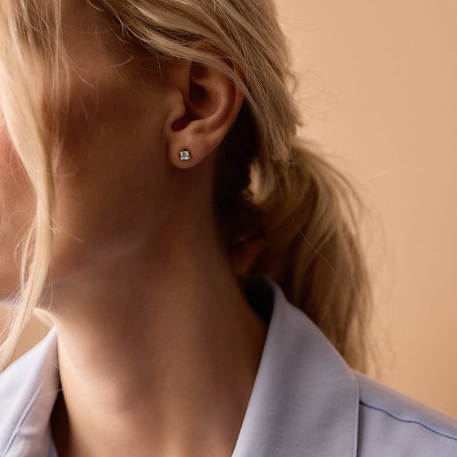 Oorbellen Blomdahl titanium goudkleurig knopje 5 mm. aqua zirconiasteentje