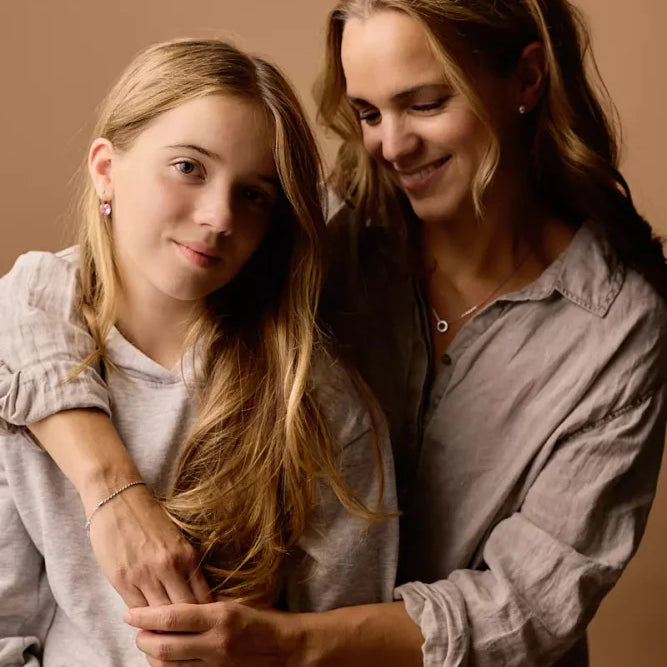 Een volwassen vrouw met een tienermeisje met allebei oorbellen in.