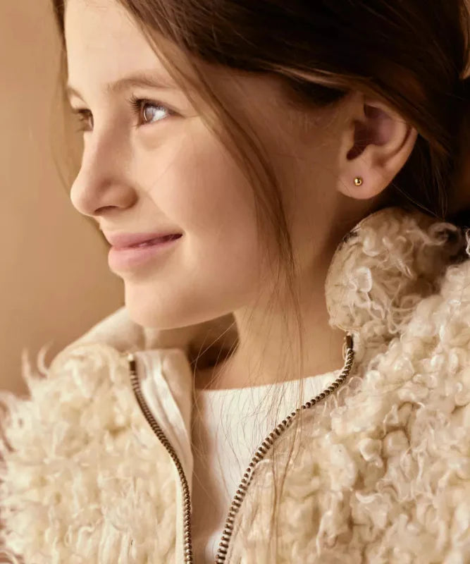 Een meisje met oorbellen Blomdahl titanium knopje 4 mm. goudkleurig (incl. achterkantjes) - Staartjes en Strikjes