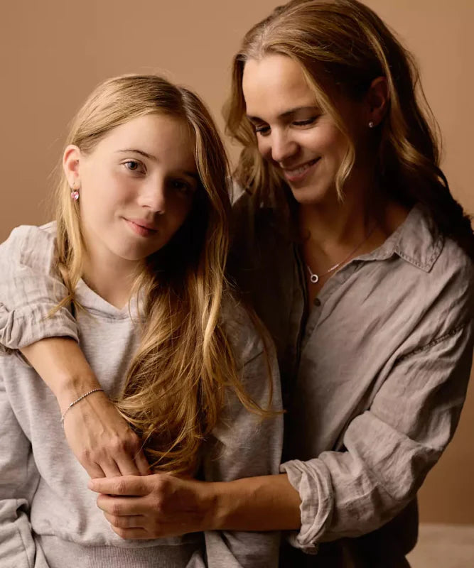 Een volwassen vrouw met een tienermeisje met allebei oorbellen in.